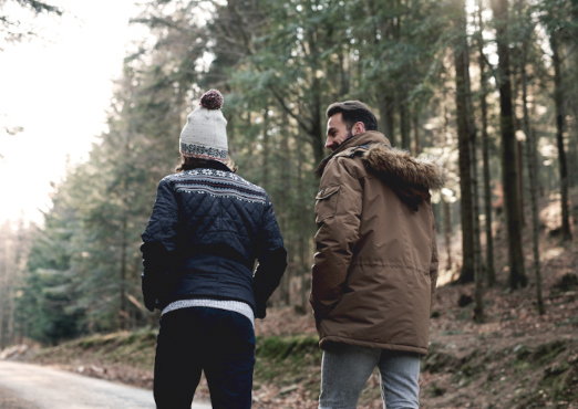 Two people walking together along a forest path, representing therapeutic support in a calm, natural setting.