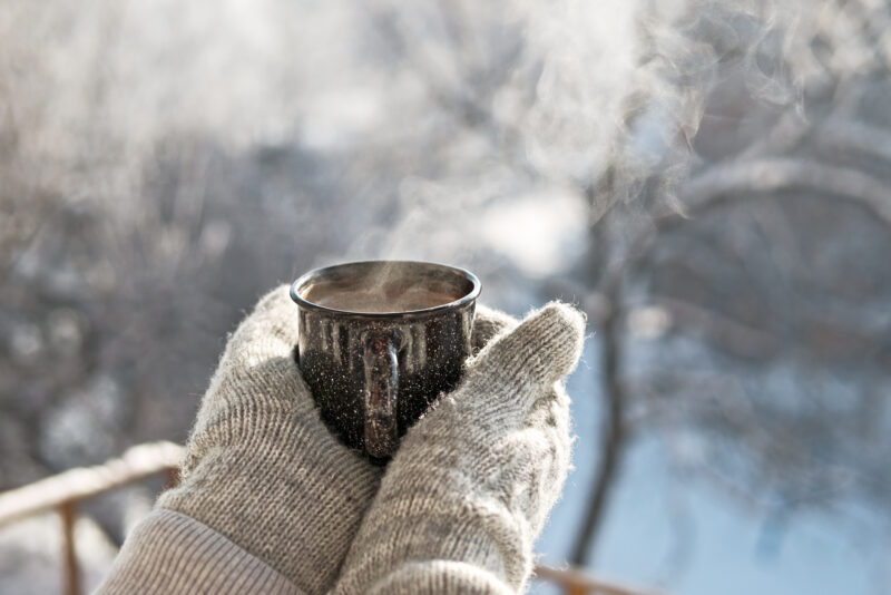 Hands holding a warm mug, representing grounding and gentle boundaries during holiday stress.