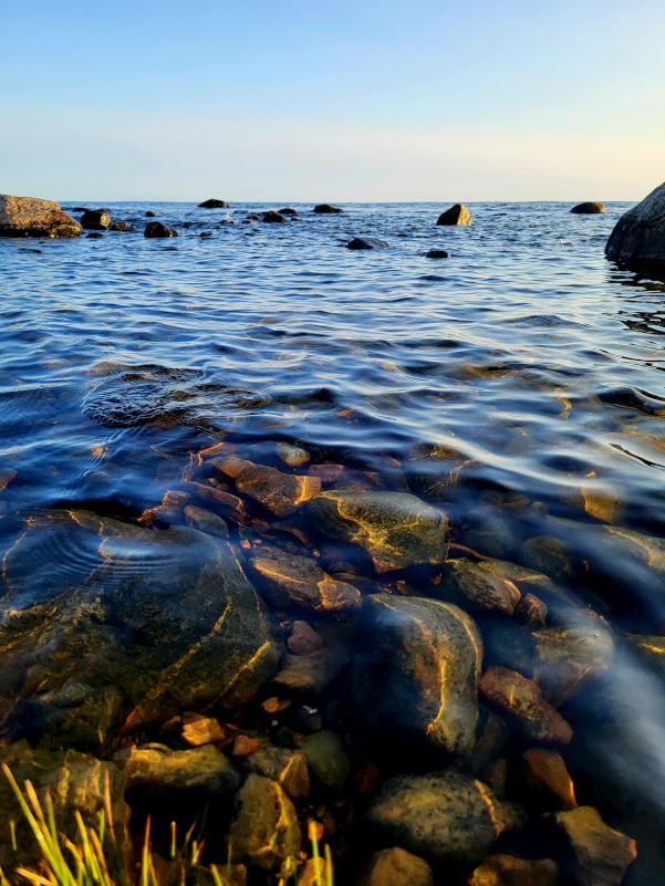 Clear, gently moving water over smooth stones, symbolizing the calming and settling effect of ART therapy on the nervous system.
