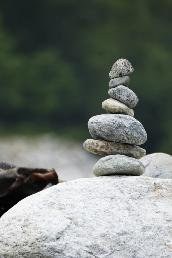 A small stack of stones balanced carefully on a rock, reflecting the quiet effort of always holding everything together.
